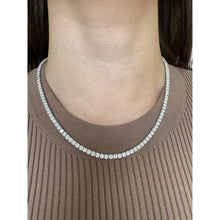 Woman wearing lab grown diamond tennis necklace with four prongs in white gold. 