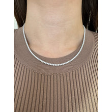 Woman wearing lab grown tennis necklace in white gold. 
