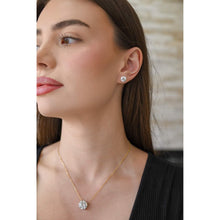 Woman wearing lab grown round diamond pendant on a yellow gold chain.