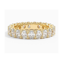 Front view of a oval lab grown diamond eternity band set in yellow gold.